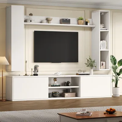 A white TV entertainment unit with a large black TV mounted on the wall above it, set in a living room environment.