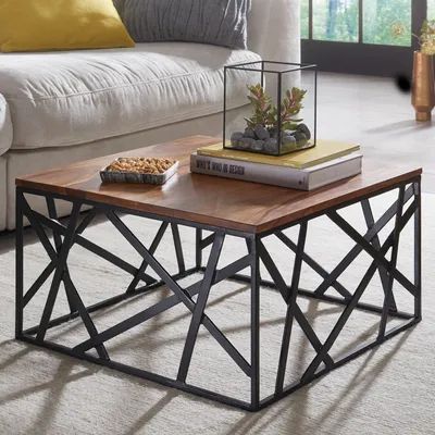 A coffee table with a wooden top and a black metal base, placed in a living room setting next to a sofa.