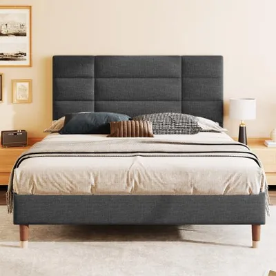 A bed with a headboard and bedding in a room.