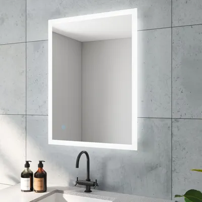 A modern bathroom vanity with a lit mirror, sink, and faucet.