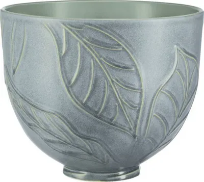 A close-up studio shot of a ceramic mixing bowl with a leaf pattern.