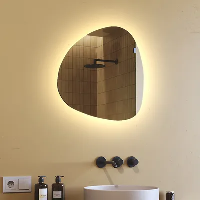 A bathroom scene with a sink, faucet, soap dispensers, and an illuminated mirror.