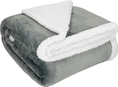 A folded gray and white sherpa blanket.