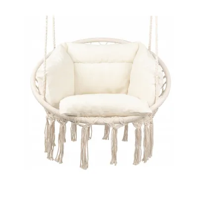 A beige macrame hanging chair with cushions, suspended by ropes against a white background.