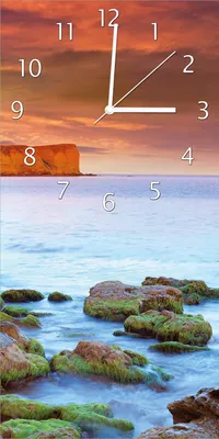 Produktbild von Wallario Design Wanduhr bedruckt, Größe 30 x 60 cm, Motiv: Sonnenaufgang am Meer mit Landzunge und Felsen im Wasser