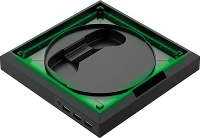 A black docking station with green LED lighting, viewed from a high angle.