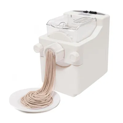 A white electric pasta maker is shown with fresh pasta being extruded onto a white plate.