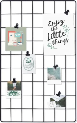 A black metal grid board displaying various photos and cards attached with clips.