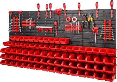 A wall-mounted tool organization system with numerous red storage bins and various tools displayed on hooks.