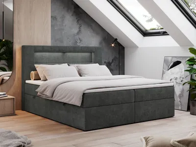 A bedroom with a bed, skylights, and a mirror.