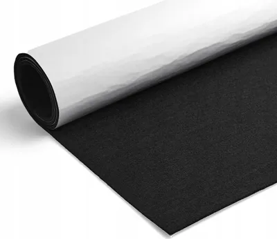 A roll of black felt with a white backing is partially unrolled on a white surface.