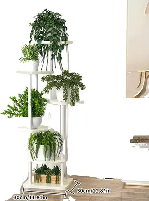A white multi-tiered plant stand filled with various green plants, set against a plain white background.