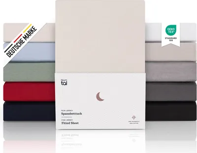 A stack of folded fitted sheets in various colors, with a product box in the foreground.