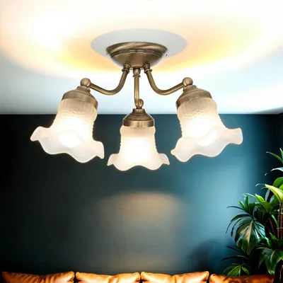 A ceiling light fixture with three glass lampshades is shown against a dark blue wall and a white ceiling.