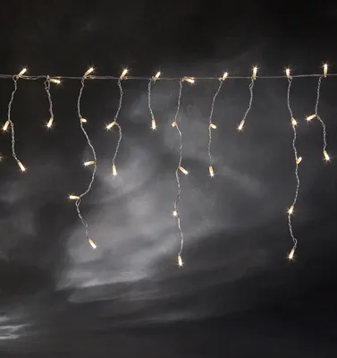 A string of icicle lights hangs against a dark, textured background.