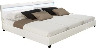A white LED bed with pillows and a throw blanket.