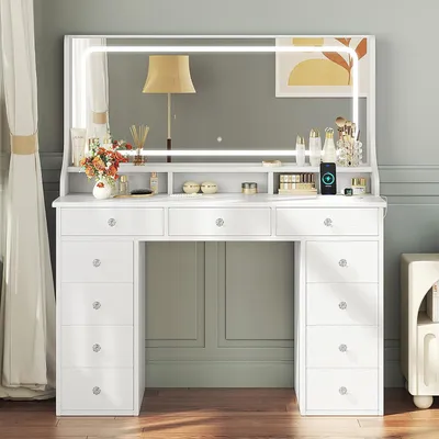 A white vanity table with a large LED mirror and drawers, decorated with makeup and accessories.