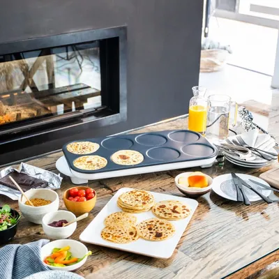 A breakfast scene with crepes, juice, and coffee next to a fireplace.