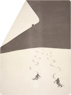 A blanket with a skiing scene depicted on it.