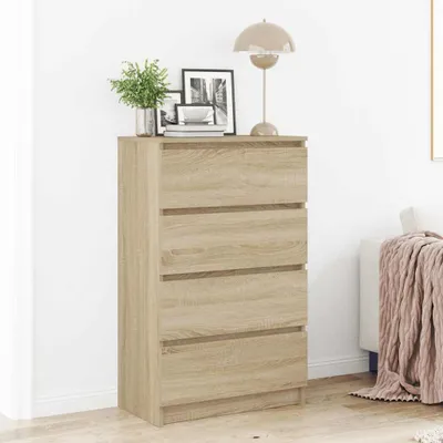 A wooden chest of drawers with decorative items on top, placed against a white wall.