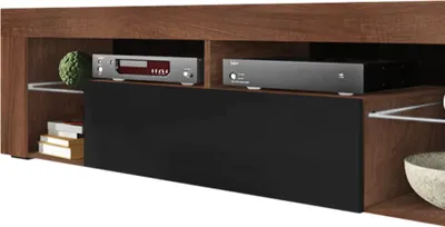 A close-up view of a modern TV lowboard with compartments and electronic devices.