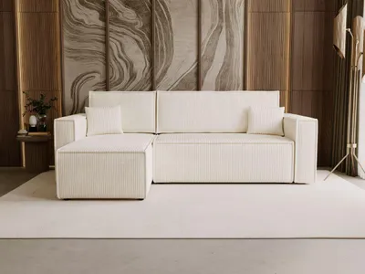 A modern beige sectional sofa with a chaise lounge is shown in a well-lit living room setting.