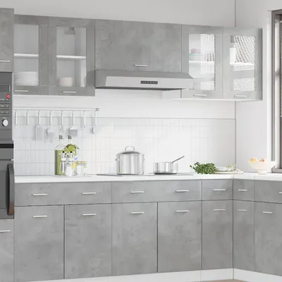 A modern kitchen interior with grey cabinets and a range hood.