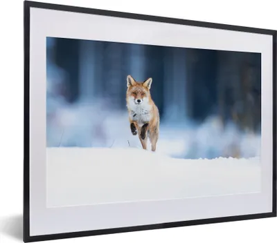 A framed poster of a fox running in the snow.