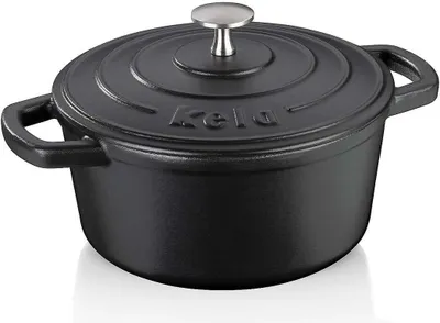 A black cast iron pot with a silver lid handle sits on a white surface.