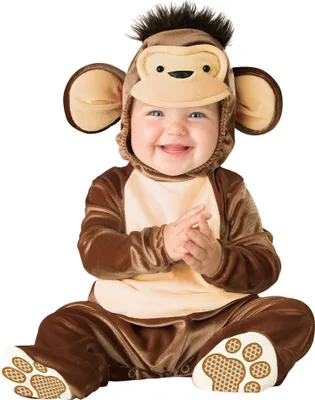 A baby wearing a monkey costume, sitting and clapping.