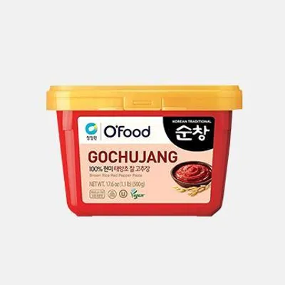 A red tub of Gochujang paste with a yellow lid, against a white background.