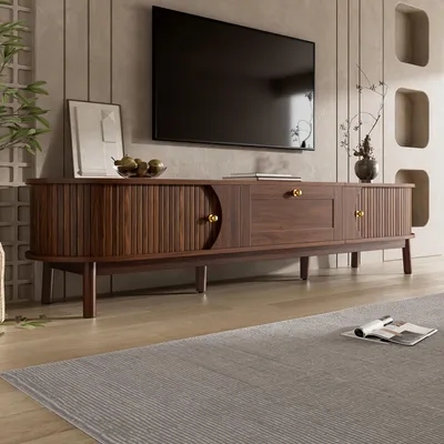 A modern living room with a TV stand and a TV mounted on the wall.