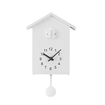 A white cuckoo clock with a pendulum, shown against a white background.