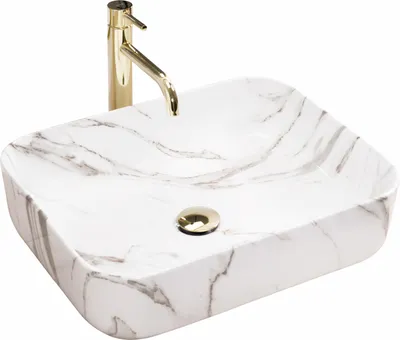 A white marble-patterned sink with a gold faucet.