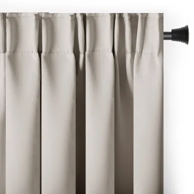 A close-up view of a light beige curtain hanging from a black curtain rod.