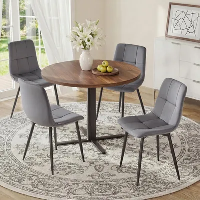 A dining set with a round table and four chairs in a room.