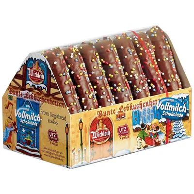 A box of chocolate-covered gingerbread cookies shaped like houses, decorated with colorful sprinkles.