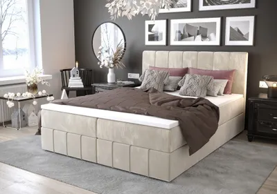 A stylish bedroom with a large bed, a round mirror, and wall art.