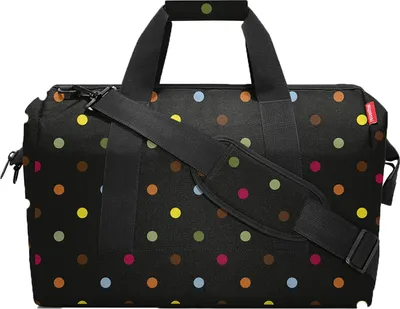 A black duffel bag with colorful polka dots.