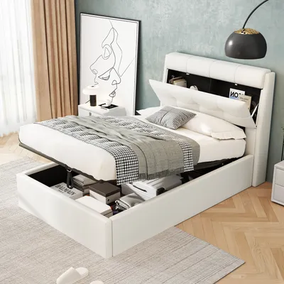 A white upholstered bed with storage is shown in a bedroom setting, with the storage compartments open and filled with items.