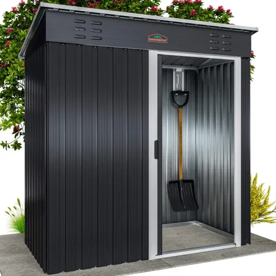 A black metal garden shed with a sliding door, a shovel hanging inside, and some greenery around it.