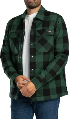 A man wearing a green and black plaid shirt.
