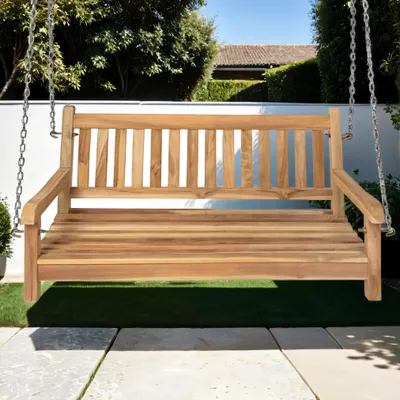 A wooden swing bench is shown outdoors on a patio with a lawn and trees in the background.