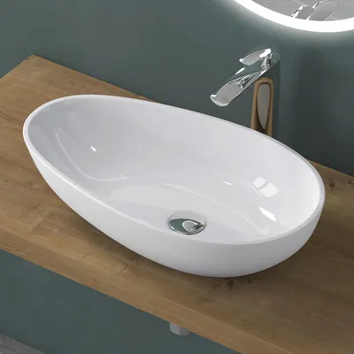 A white oval vessel sink sits on a wooden countertop, with a modern chrome faucet behind it.