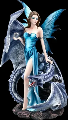 A figurine of a fairy with blue wings and a blue dress, holding a crystal ball, standing next to a blue dragon.