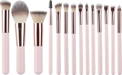 A set of 14 makeup brushes with pink handles and rose gold ferrules, arranged in a line against a white background.
