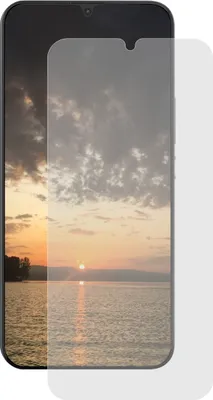 A screen protector is placed over a smartphone displaying a sunset over a body of water.