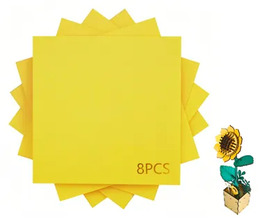 A stack of yellow square papers and a small wooden sunflower model.
