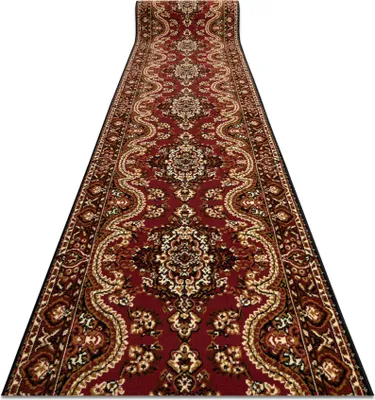 A long, patterned runner rug is shown from a low angle, extending into the distance against a white background.