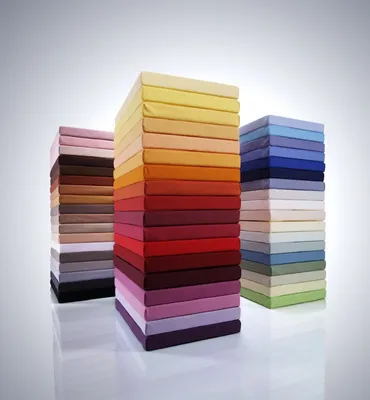 Three stacks of colorful fabric swatches or samples, arranged in a gradient of colors.